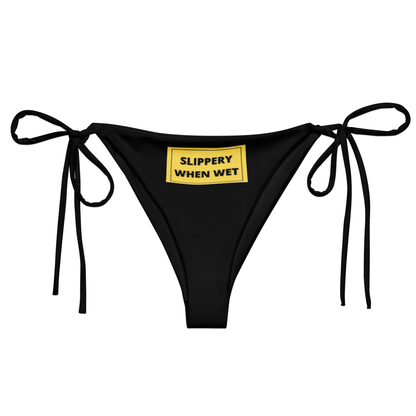 A black bikini bottom from Sensual Muse with a yellow sign on the front. The sign on the front says 'Slippery When Wet'. It has black writing in a yellow box.